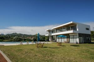 uma casa com cadeiras e um relvado com um edifício em São Vicente Lodge - Panoramic Retreat em Capelas