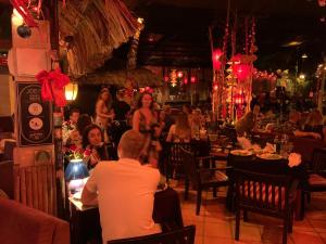 een groep mensen die aan tafel zitten in een restaurant bij Joe's Cafe & Garden Resort in Mũi Né