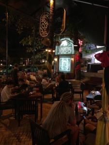 eine Gruppe von Menschen, die nachts in einem Restaurant sitzen in der Unterkunft Joe's Cafe & Garden Resort in Mui Ne