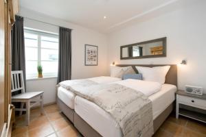 a bedroom with a large bed and a mirror at Sylt Island House in Westerland (Sylt)