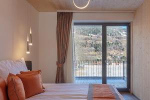a bedroom with a bed and a large window at ARTMUR Apartment in Sankt Georgen ob Murau
