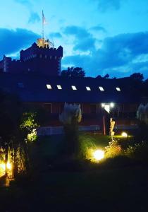 un bâtiment avec des lumières dans une cour la nuit dans l'établissement The Lakeside - Burghotel zu Strausberg, à Strausberg