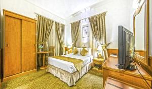 Schlafzimmer mit einem Bett und einem Flachbild-TV in der Unterkunft Zain International Hotel in Dubai