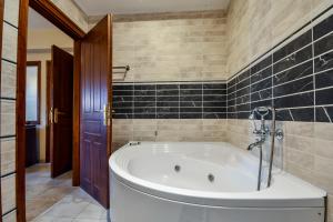 a bath tub in a bathroom with black tiles at Archontiko Liamas in Stavros