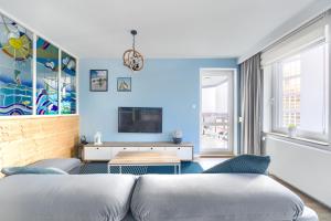 sala de estar con paredes azules y sofá en Meerblick und Ruhe, en Międzyzdroje