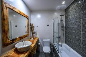 a bathroom with a sink and a mirror and a tub at Archontiko Liamas in Stavros
