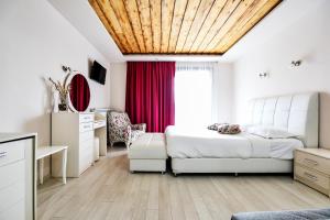 a bedroom with a bed and a red curtain at Archontiko Liamas in Stavros