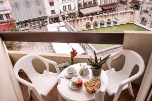 a table and chairs on a balcony with a view at Hôtel le Vascon in Dax