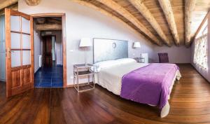 ein Schlafzimmer mit einem großen Bett und Holzboden in der Unterkunft Casa Insol in Denúy