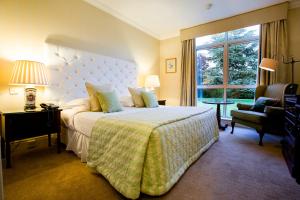 a bedroom with a bed and a chair and a window at The Keadeen Hotel in Newbridge