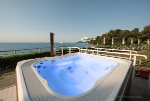 a jacuzzi tub with the ocean in the background at Excelsior Palace Portofino Coast in Rapallo