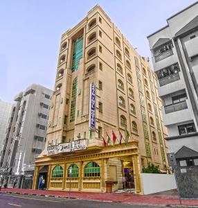 a tall building with flags in front of it at Zain International Hotel in Dubai