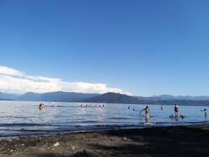 a group of people in the water at a beach at Cabaña de Lore in Licán Ray