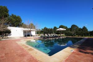 - une piscine avec des chaises et un parasol dans l'établissement Villa Sa Barda, à Sant Antoni de Portmany