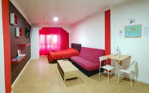 Sala de estar con cama roja y mesa en Apartamento Adargoma tipo loft en Vecindario
