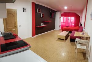 cocina y sala de estar con sofá rojo en Apartamento Adargoma tipo loft, en Vecindario