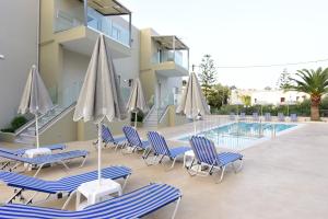 een groep stoelen en parasols naast een zwembad bij Blue Horizon Apartments in Balíon