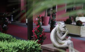 a statue of a squirrel sitting on a bench in front of a building at The Lakeside - Burghotel zu Strausberg in Strausberg