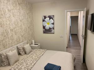- une chambre avec un lit orné d'une peinture florale sur le mur dans l'établissement LOVELY APARTMENT- TERRACE+BALCONY+WI-FI, à Badalona
