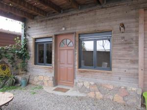 a wooden house with a red door and two windows at Appartement en bois in Sète
