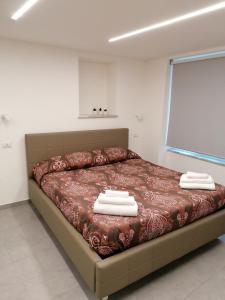 a bedroom with a bed with towels on it at Vico Spina 5 in Milazzo