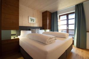 una camera da letto con due letti con lenzuola bianche e una finestra di Wally Berg-Appartements a Zams