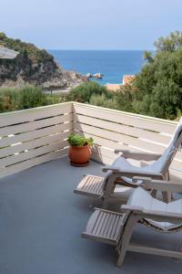 uma varanda com duas cadeiras e o oceano ao fundo em Villa Christianna Studios em Áyios Nikítas