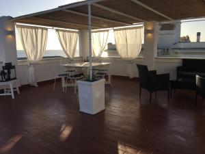 Cette chambre comprend une table, des chaises et des fenêtres. dans l'établissement La terrazza sul mare, à Santa Marinella
