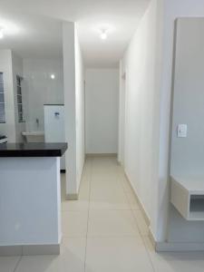 a white kitchen with white walls and a black counter at Aquaville Atalaia Apartamentos in Luis Correia