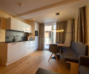 eine Küche und ein Wohnzimmer mit einer Couch und einem Tisch in der Unterkunft Wally Berg-Appartements in Zams