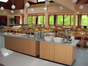 een schoolcafetaria met een bar met stoelen en tafels bij Jutel Obertraun in Obertraun