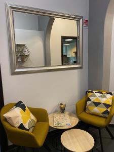 a living room with a mirror and two chairs and a table at Guest House Rome in Rome