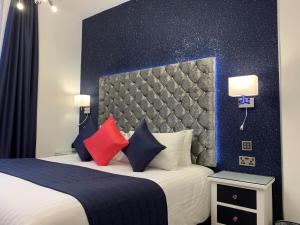 Habitación de hotel con cama con almohadas rojas y azules en The 25 Boutique B&B - Adults Only, en Torquay