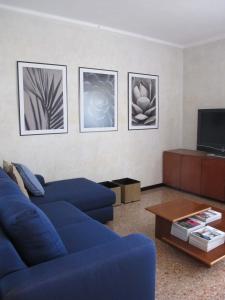een woonkamer met een blauwe bank en foto's aan de muur bij Lagoon View Apartment in Venetië-Lido