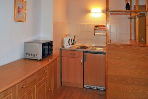a small kitchen with a microwave and a stove at Ferienwohnung "An den Kurwiesen" in Masserberg +17 photos