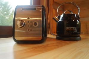 a toaster and a tea kettle sitting on a table at Smolnikowe Klimaty - Chyżula - Sauna&Jacuzzi in Komańcza