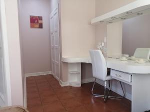 a bathroom with a white desk and a mirror at Easy Inn Guesthouse in Welkom