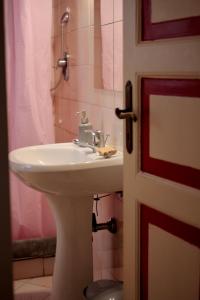 La salle de bains est pourvue d'un lavabo blanc et d'une douche. dans l'établissement ArtRoom in appartment, à Gênes
