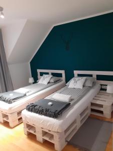 2 camas individuales en una habitación con una pared verde en Wypoczynek Pod Jelonkiem, en Krościenko nad Dunajcem