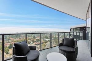 a balcony with two chairs and a table at Domi Serviced Apartments in Glen Waverley