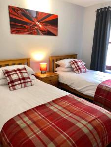 a bedroom with two beds and a picture on the wall at Rendezvous in Aviemore
