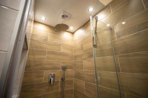 a bathroom with a shower with wooden tiles at Smart Apartments in Kyiv Center in Kyiv