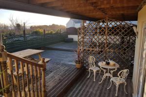 a patio with a table and chairs on a deck at Sister's Apartment in Llanelli