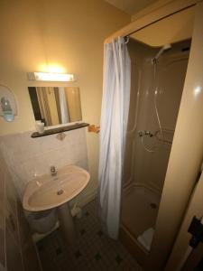 a bathroom with a shower and a sink at Hôtel Thermidor in Nevers
