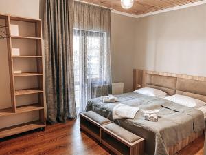 una camera da letto con un letto e una grande finestra di Hotel panorama svaneti a Mestia