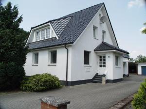 a white house with a black roof at La Domus Premium Osnabrück Lotte in Lotte