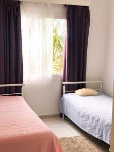 una camera da letto con due letti e una finestra di Lighthouse Beach apartment a Paphos