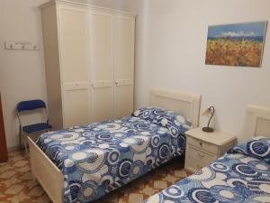 a bedroom with two beds and a dresser and a picture at Appartamento Rosamarina in Torre Lapillo