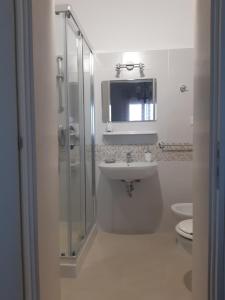 a bathroom with a sink and a shower and a toilet at Appartamento Rosamarina in Torre Lapillo