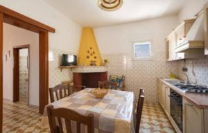 a kitchen and dining room with a table and chairs at Appartamento Rosamarina in Torre Lapillo